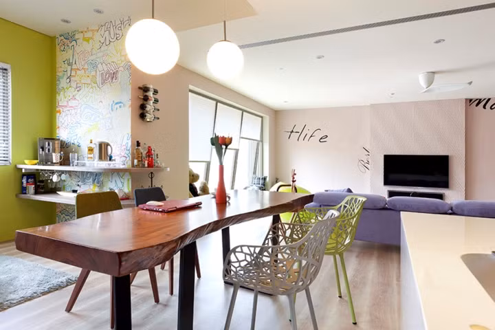 Bàn gỗ tự nhiên đặt cạnh ghế sắt cắt khắc tinh xảo, tạo sự tương phản đầy thú vị.