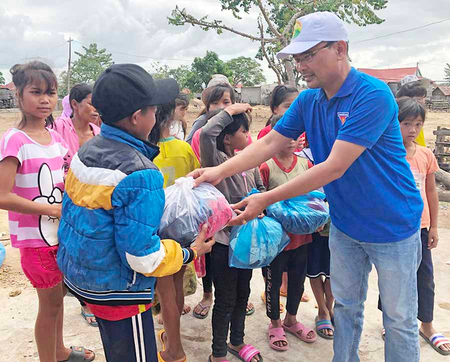 Nhóm tình nguyện tặng áo quần cho các em thiếu nhi. Ảnh: P.L