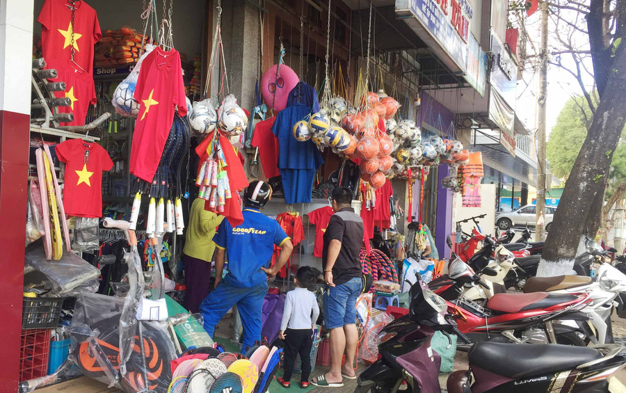  Đông đảo người dân Pleiku đi mua áo, băng rôn cổ vũ cho đội tuyển. Ảnh: Văn Ngọc