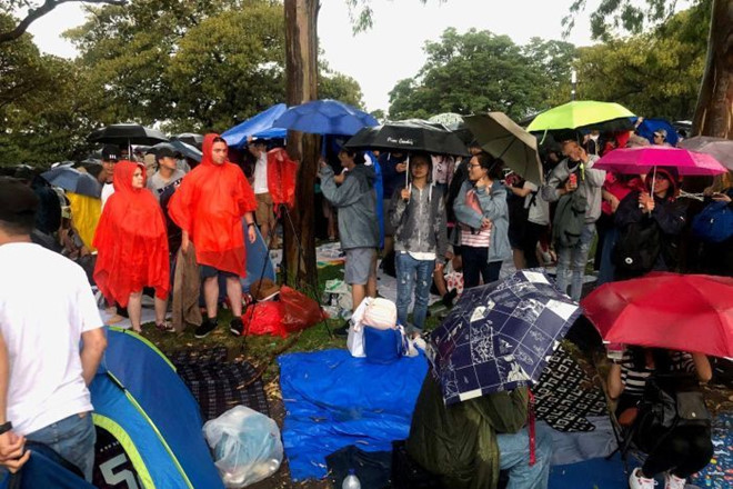 Người dân và du khách đội mưa chiều 31/12 để giữ chỗ xem pháo hoa Sydney. Ảnh: SMH, ABC.