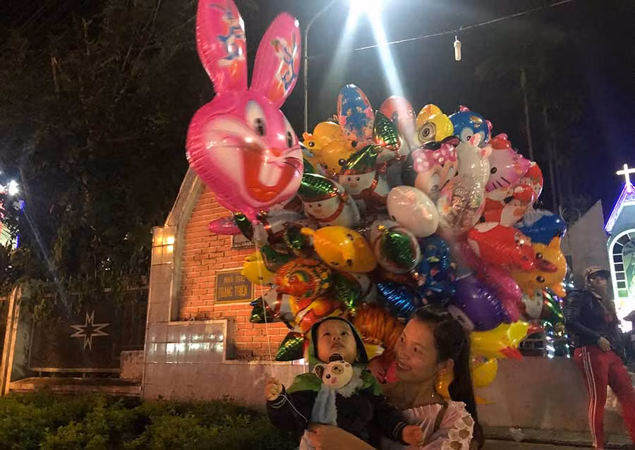 Em nhỏ háo hức được bố mẹ mua cho đồ chơi bóng bay. Ảnh: Ngọc Thu