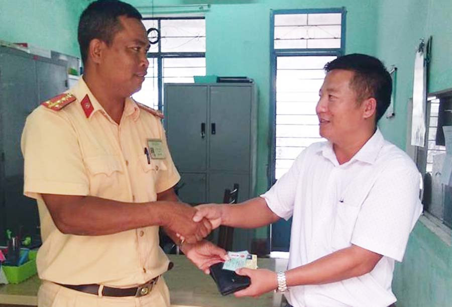 Đại úy Nay Thách trả lại tài sản cho anh Phạm Văn Lĩnh. Ảnh: Văn Ngọc