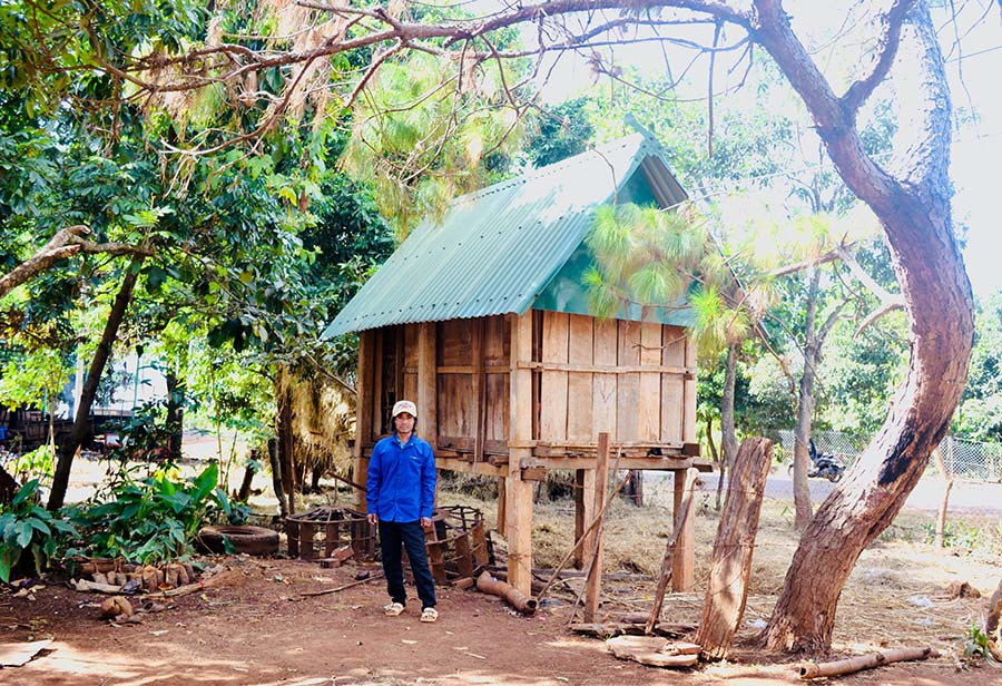  Ông Rơ Châm Bloch trước kho thóc của gia đình mình. Ảnh: L.H