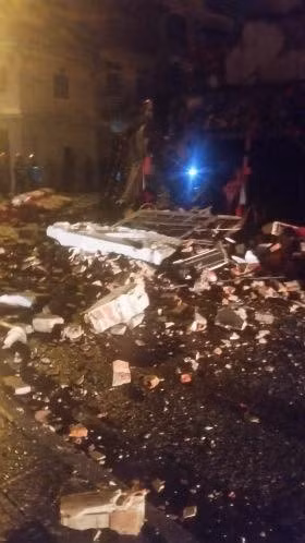 Gạch, đá tràn ra đường sau vụ đổ sập. Ảnh: Văn Bin