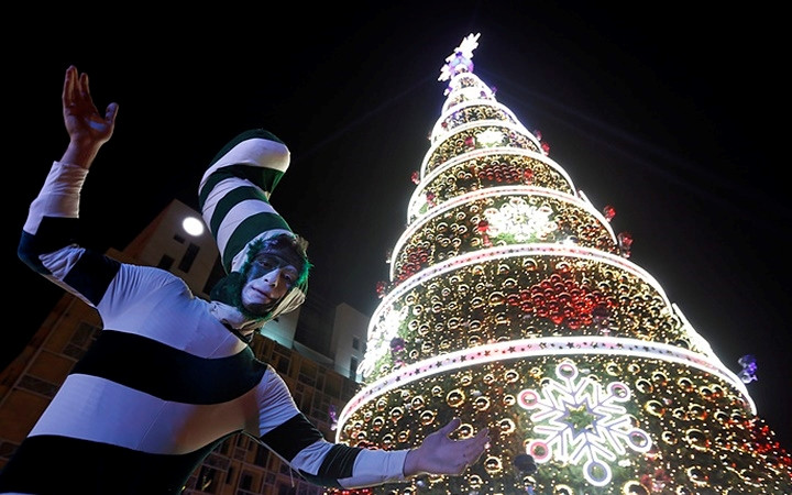 Người đàn ông trong trang phục cây kẹo tham gia lễ thắp sáng cây thông Noel tại thủ đô Beirut, Lebanon. Ảnh: AP.