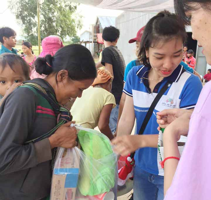 Thành viên của nhóm tình nguyện Những ước mơ xanh phát quà cho người nghèo. Ảnh: Hoàng Hiền