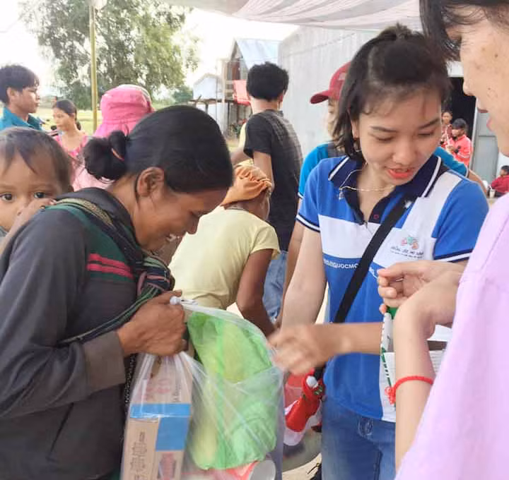 Thành viên của nhóm tình nguyện Những ước mơ xanh phát quà cho người nghèo. Ảnh: Hoàng Hiền