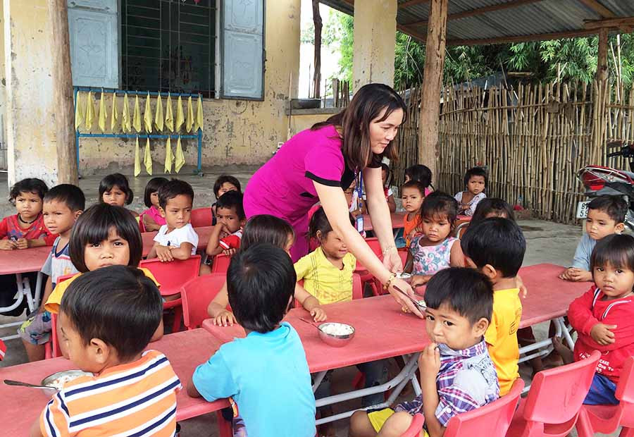  Cô Hoàng Thị Bảy chăm sóc học sinh trong một giờ ăn trưa. Ảnh: Như Loan