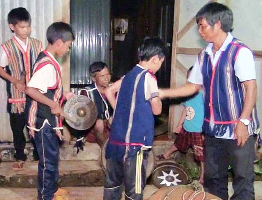  Ông Rơ Mah Khơl (bìa phải) hướng dẫn các em nhỏ làng Khóp đánh cồng chiêng. Ảnh: N.S