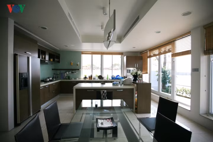  Phòng ăn ấm áp và hiện đại kế bên khoảng vườn sau có lối đi ra hồ.