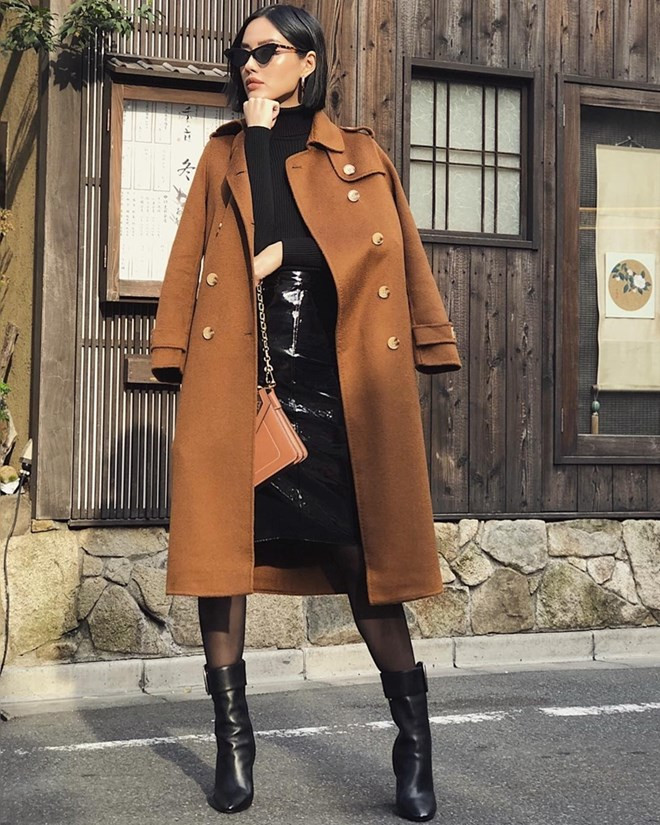 Áo len cổ lọ phối chân váy và boots da tiệp màu đen, thêm áo khoác dáng dài tông nâu trầm là phép cộng lý tưởng để Khánh Linh ''ăn gian'' chiều cao, đồng thời tôn vẻ sang chảnh, sành điệu.