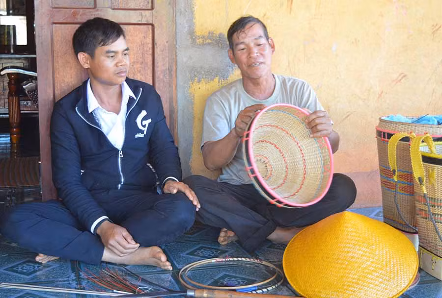  Ông Siu Lơl đang hướng dẫn cách đan gùi nắp cho một thanh niên trong làng. Ảnh: Phương Dung