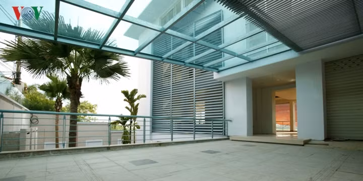 Nằm ngay sát đầm sen Quảng Bá, hồ Tây, công trình này có đặc điểm khác thường là chênh cốt, thấp hơn so với mặt đường tiếp cận cổng chính. Do đó có một tầng hầm là không gian kế liền với đường dạo quanh hồ. Lối vào tầng 1 là một sảnh rộng vào gara. Phần còn lại của tầng 1 là phòng khách rộng lớn.