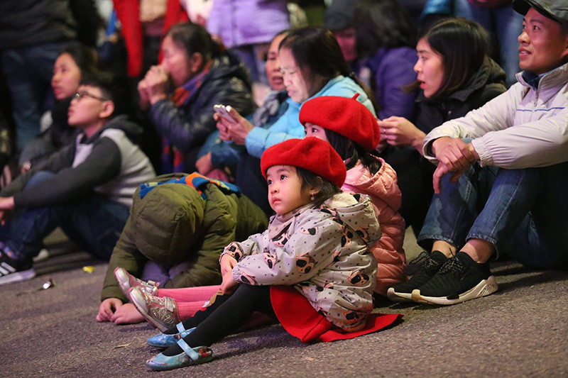 Các em nhỏ ngồi tại tượng đài Lý Thái Tổ chờ đợi thời khắc bước sang năm mới. Ảnh: Phạm Hải Các em nhỏ ngồi tại tượng đài Lý Thái Tổ chờ đợi thời khắc bước sang năm mới. Ảnh: Phạm Hải