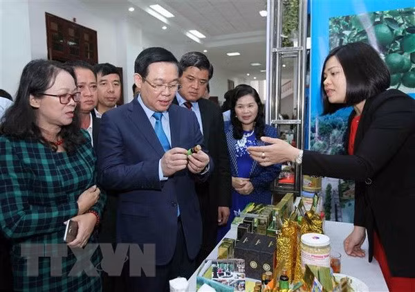 Phó Thủ tướng Vương Đình Huệ cùng các đại biểu tham quan gian hàng trưng bày sản phẩm nông sản của tỉnh Yên Bái. (Ảnh: Quý Trung/TTXVN)