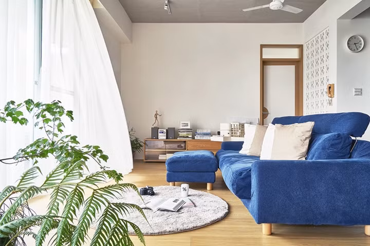 Ghế sofa đặt đối diện với cửa sổ để lấy ánh sáng, chiếc thảm trải sàn hình tròn có thể dùng làm đệm ngồi khi chủ nhân muốn thay đổi vị trí đọc sách.