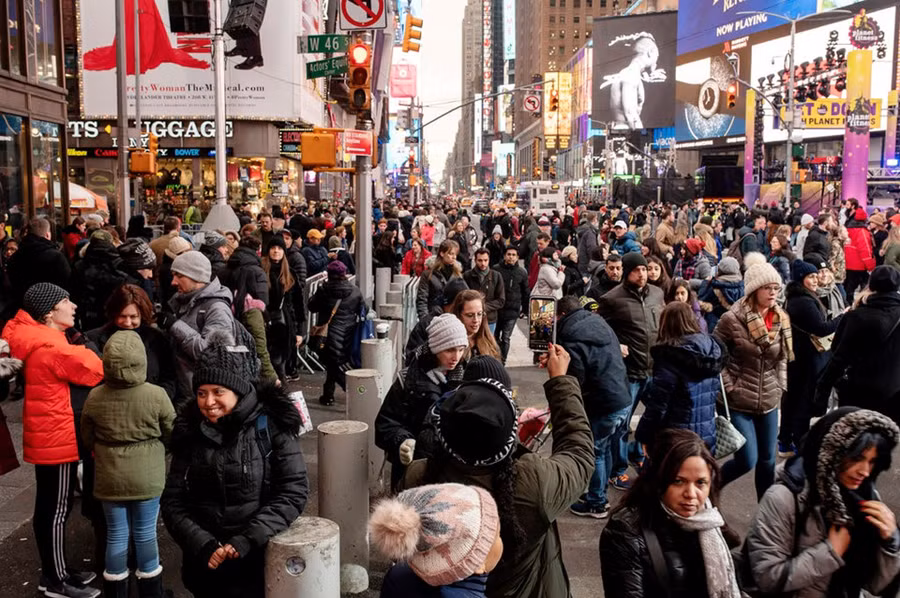 Như thường lệ, Quảng trường Thời đại trở nên vô cùng nhộn nhịp và đông đúc trong những ngày cuối năm. Nhiều người có mặt New York dịp này để tận mắt chứng kiến cảnh quả cầu pha lê khổng lồ được thả xuống vào thời khắc giao thừa ở quảng trường nổi tiếng. Ảnh: New York Times.