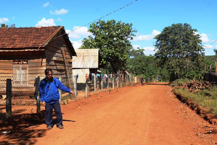 Ông Rơ Châm Hiết bên tuyến đường được mở rộng nhờ phần đất đã hiến của gia đình. Ảnh: H.T  Ông Rơ Châm Hiết bên tuyến đường được mở rộng nhờ phần đất đã hiến của gia đình. Ảnh: H.T