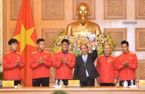  Đại diện Ban huấn luyện và Đội tuyển Việt Nam trân trong tặng Thủ tướng trái bóng sử dụng tại AFF Cup 2018. Ảnh: VGP/Quang Hiếu