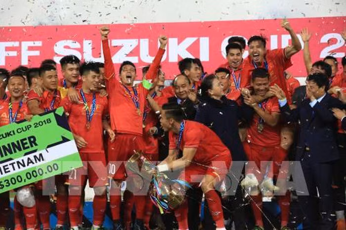 Các cầu thủ đội tuyển Việt Nam ăn mừng chiến thắng bên chiếc cup vô địch. Ảnh: Trọng Đạt - TTXVN