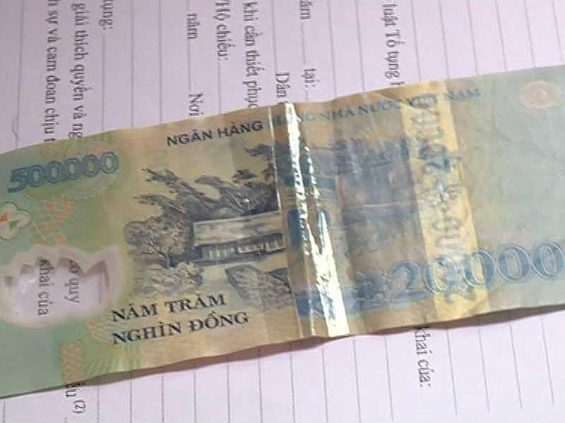 Tờ tiền 20.000 đồng bị cắt, ghép vào tờ tiền 500.000 đồng. Ảnh: CAO DIÊN Tờ tiền 20.000 đồng bị cắt, ghép vào tờ tiền 500.000 đồng. Ảnh: CAO DIÊN