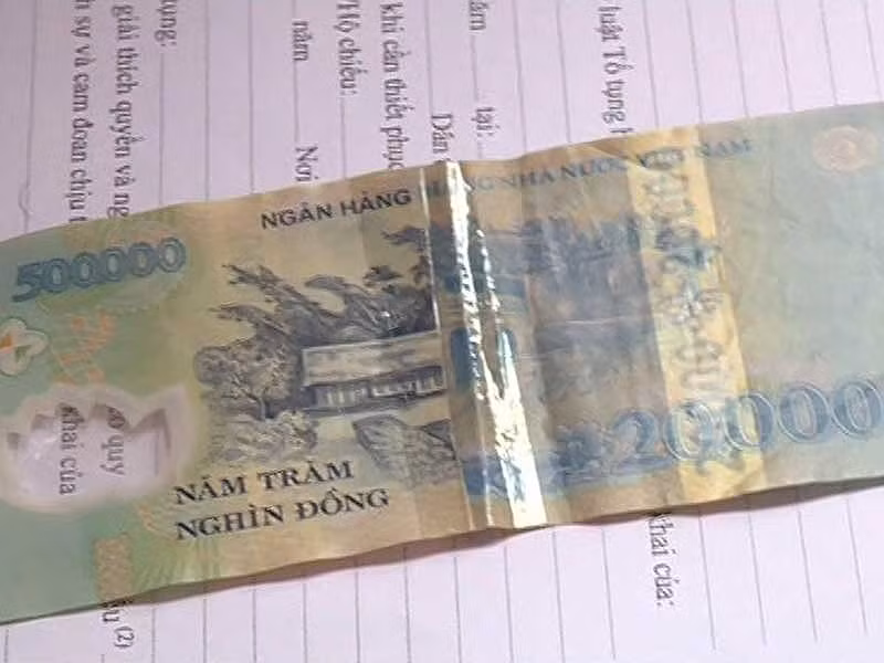  Tờ tiền 20.000 đồng bị cắt, ghép vào tờ tiền 500.000 đồng. Ảnh: CAO DIÊN