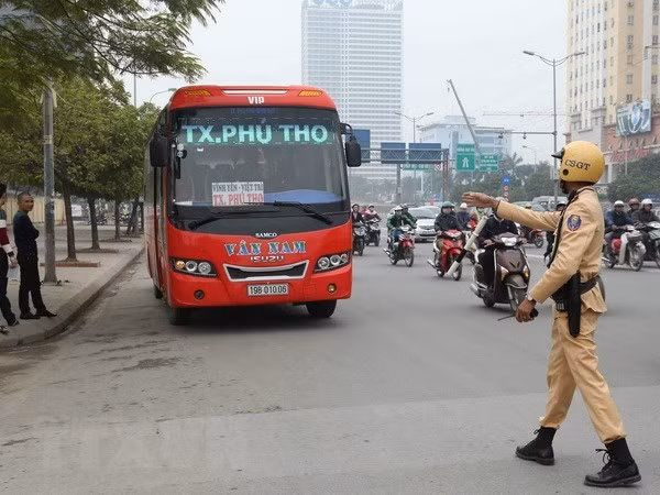 Cảnh sát giao thông xử lý trường hợp xe khách vi phạm trên đường Phạm Hùng. (Ảnh: Doãn Tấn/TTXVN)