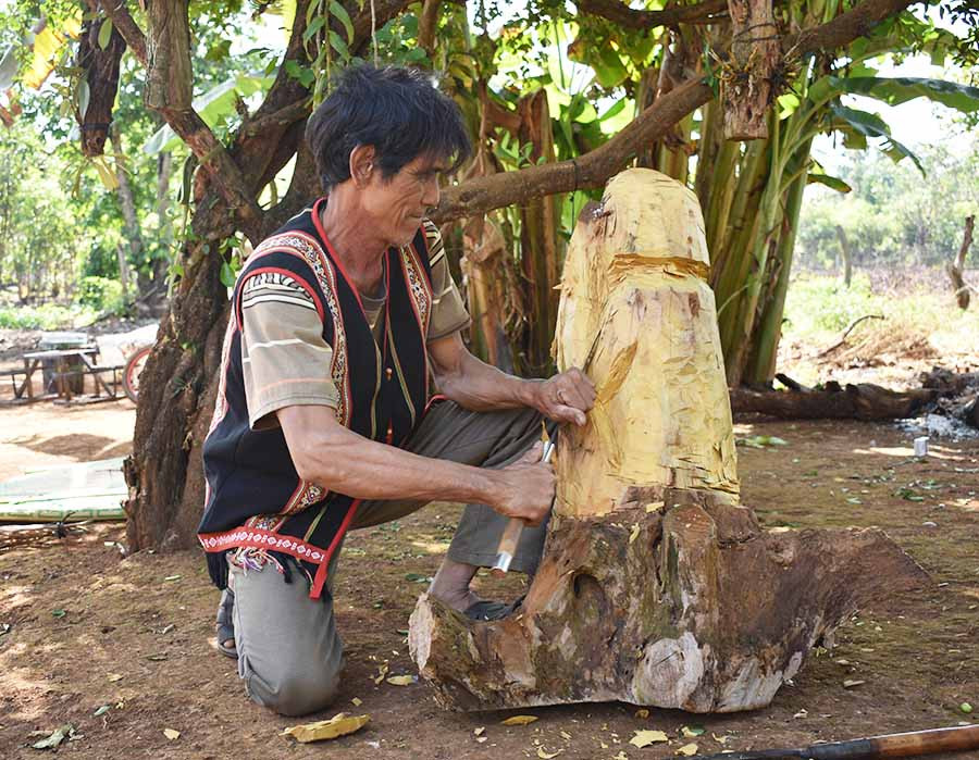  Nghệ nhân Rơ Châm BLíp đang say sưa tạc tượng. Ảnh: P.T