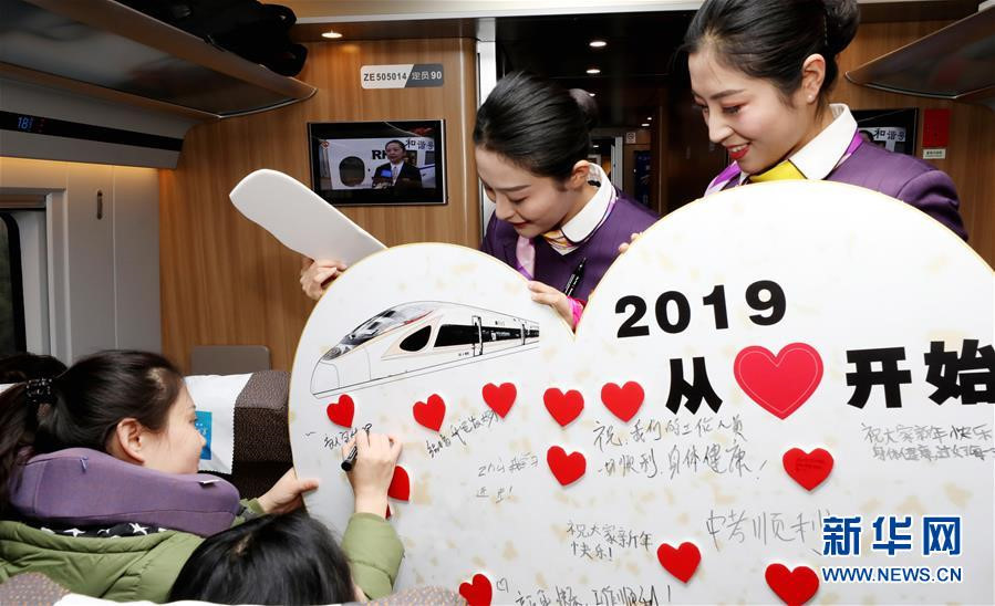 Trến chuyến tàu cao tốc từ Thượng Hải đến Bắc Kinh, Trung Quốc, hôm 30/12, nhân viên phục vụ tổ chức cho hành khách viết lời cầu chúc năm mới. Tấm biển trong ảnh đề dòng chữ (lớn): 