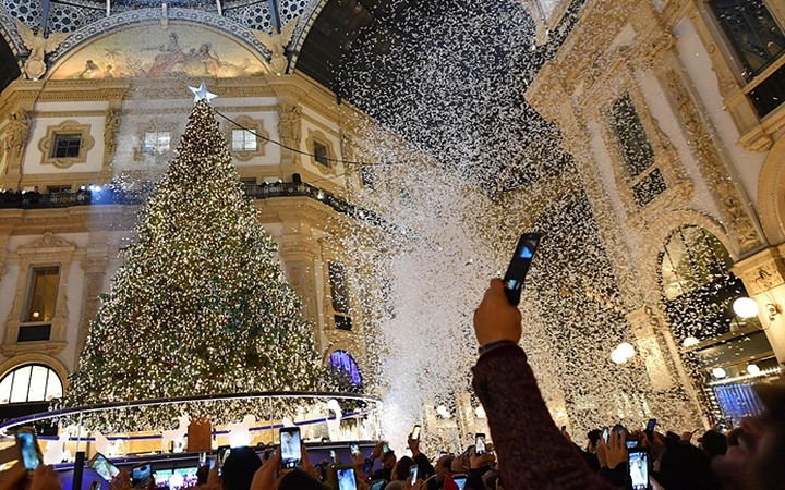 Người dân và du khách chụp lại khoảnh khắc thắp sáng cây thông Noel tại Milan, Italy. Ảnh: EPA-EFE 