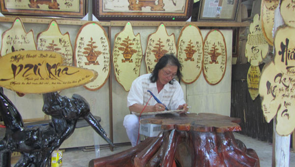 Nghệ nhân Dzũ Kha viết thơ bằng bút lửa. Ảnh: N.N.P Nghệ nhân Dzũ Kha viết thơ bằng bút lửa. Ảnh: N.N.P