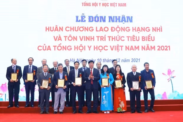 Thứ trưởng Bộ Y tế Đỗ Xuân Tuyên trao biểu trưng tôn vinh các tri thức tiêu biểu của Tổng hội Y học Việt Nam. (Ảnh: Văn Điệp/TTXVN)