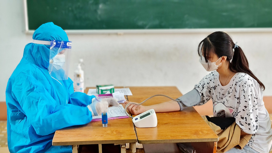 Nhân viên y tế kiểm tra sức khỏe người dân trước khi tiêm vắc xin phòng Covid-19 tại điểm tiêm Trường Tiểu học Chu Văn An (phường Tây Sơn, TP. Pleiku). Ảnh: Bá Bính Nhân viên y tế kiểm tra sức khỏe người dân trước khi tiêm vắc xin phòng Covid-19 tại điểm tiêm Trường Tiểu học Chu Văn An (phường Tây Sơn, TP. Pleiku). Ảnh: Bá Bính