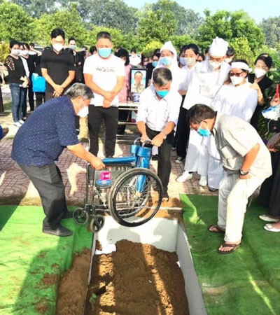 Đồng đội đưa chiếc xe lăn xuống mộ hôm tiễn thương binh Nguyễn Văn Thạnh về nơi an nghỉ cuối cùng