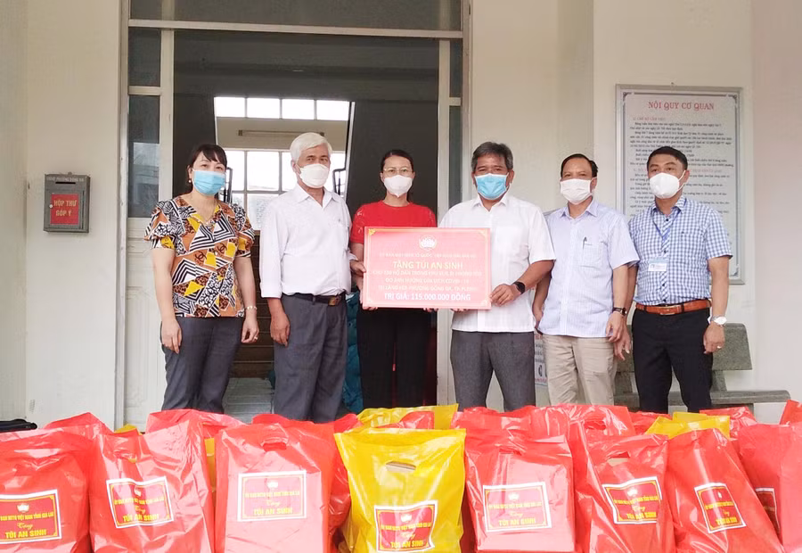 Ông Hồ Văn Điềm (thứ 3 từ phải sang)-Ủy viên Ban Thường vụ Tỉnh ủy, Chủ tịch Ủy ban MTTQ Việt Nam tỉnh trao tặng túi an sinh cho người dân làng Kép (phường Đống Đa, TP. Pleiku). Ảnh: Anh Huy