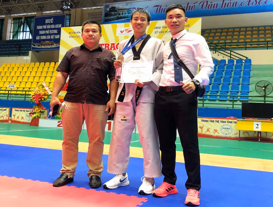 VĐV Hồ Sỹ Đức (giữa) cùng các huấn luyện viên của đoàn Gia Lai. Ảnh: Đức Nhật