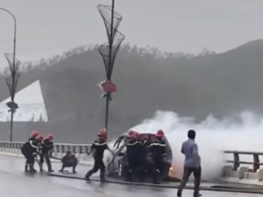 Cảnh sát phòng cháy chữa cháy và cứu nạn cứu hộ dập lửa trên ô tô. Ảnh: Cắt từ clip