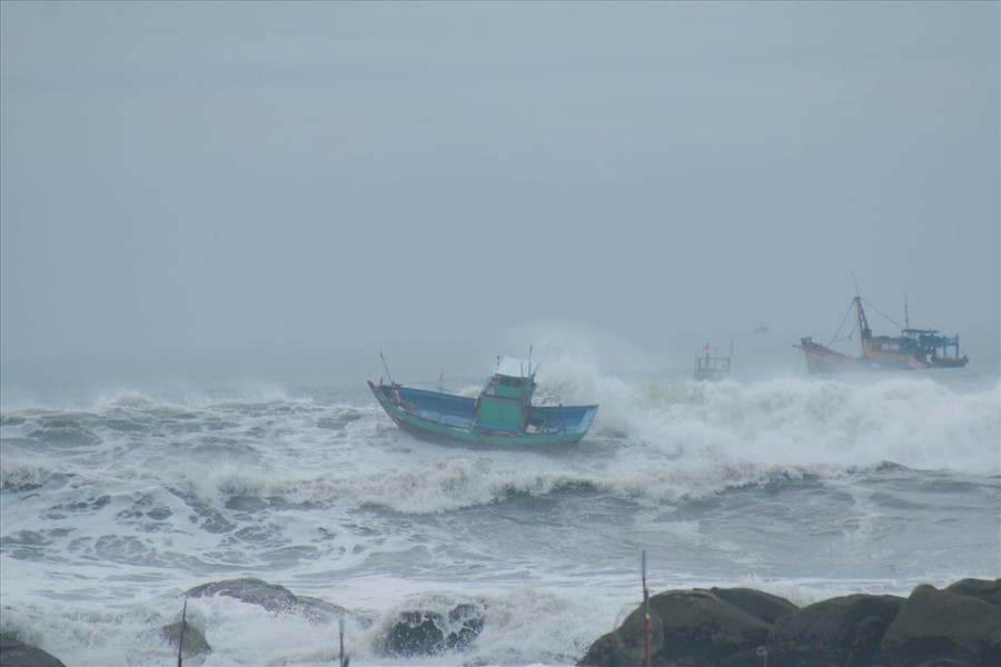 Sóng đánh phủ lên thuyền ở biển Chí Công. Ảnh: Minh Hiệu