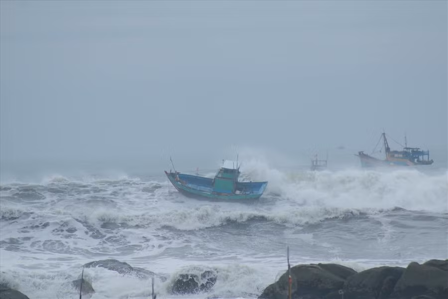 Sóng đánh phủ lên thuyền ở biển Chí Công. Ảnh: Minh Hiệu