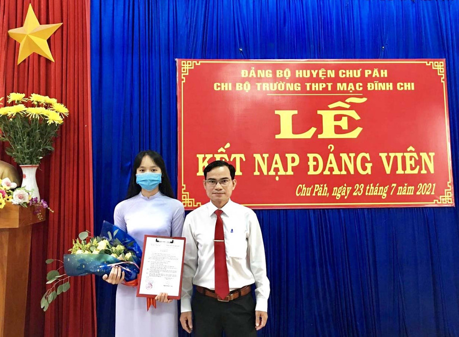  Bí thư Chi bộ nhà trường Lê Văn Tàu trao quyết định kết nạp đảng viên mới. Ảnh: Phương Dung