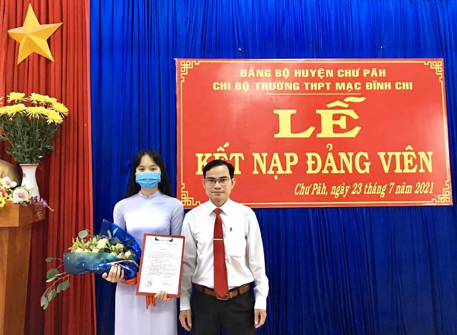  Bí thư Chi bộ nhà trường Lê Văn Tàu trao quyết định kết nạp đảng viên mới. Ảnh: Phương Dung