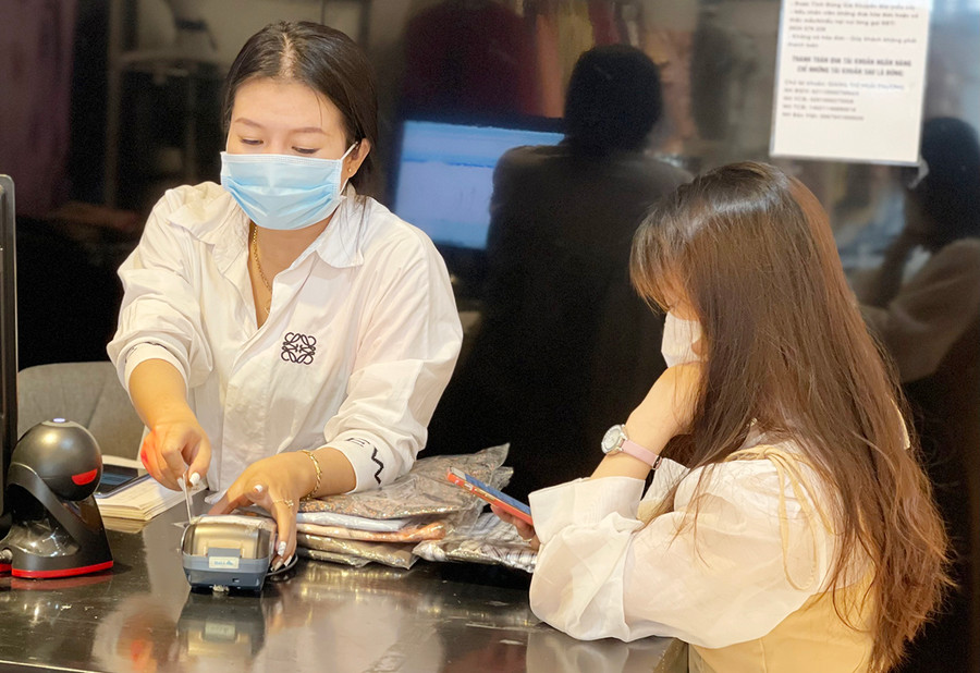 Thay vì mang theo tiền mặt, nhiều người tiêu dùng lựa chọn thẻ ATM để thanh toán. Ảnh: Sơn Ca