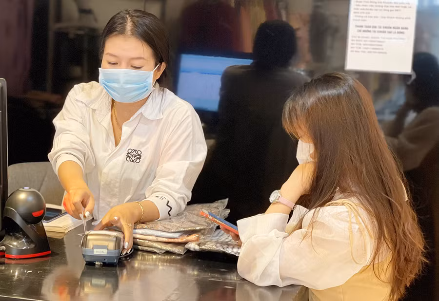 Thay vì mang theo tiền mặt, nhiều người tiêu dùng lựa chọn thẻ ATM để thanh toán. Ảnh: Sơn Ca