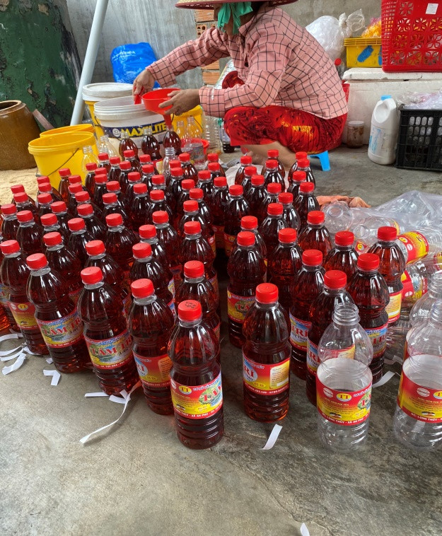 Bà Đỗ Thị Thu Hà, vợ chủ cơ sở nước mắm Tám Trí đóng chai nước mắm tại thôn Long Thủy, xã An Phú, TP Tuy Hòa, tỉnh Phú Yên.