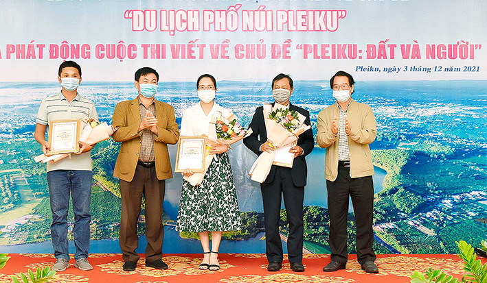 Phó Bí thư Thành ủy Pleiku Trần Xuân Quang (bìa phải) và Tổng Biên tập Báo Gia Lai (thứ hai từ trái sang) trao giải nhất cho các tác giả. Ảnh: Đức Thụy