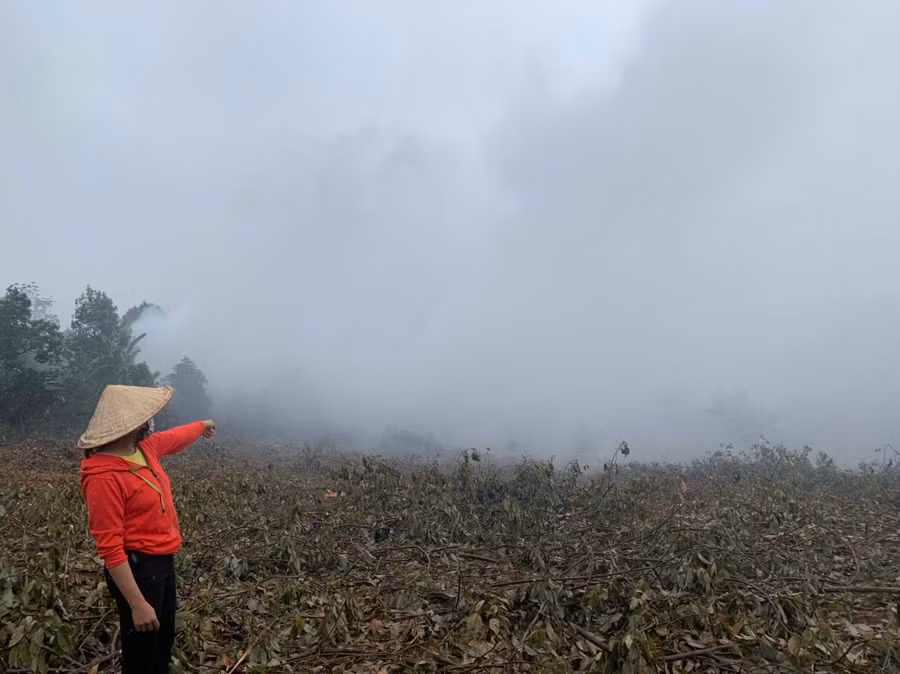 Chị Trần Thị Tài chỉ về khu vực lò sấy đang hoạt động gây khói bụi mù mịt. Ảnh: Nhật Hào