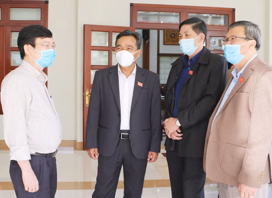 Ủy viên Ban Chấp hành Trung ương Đảng, Bí thư Tỉnh ủy, Chủ tịch HĐND tỉnh Hồ Văn Niên (thứ 2 bên trái) trao đổi với các đại biểu bên lề kỳ họp. Ảnh: Tấn Thi