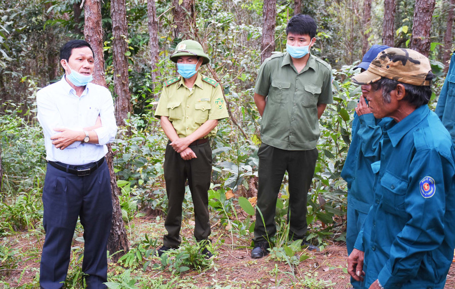 Ông Nguyễn Xuân Thưởng (bìa trái)-Phó Giám đốc phụ trách Quỹ Bảo vệ và Phát triển rừng tỉnh trao đổi với người dân nhận khoán về tình hình chi trả tiền dịch vụ môi trường rừng. Ảnh: Minh Nguyễn
