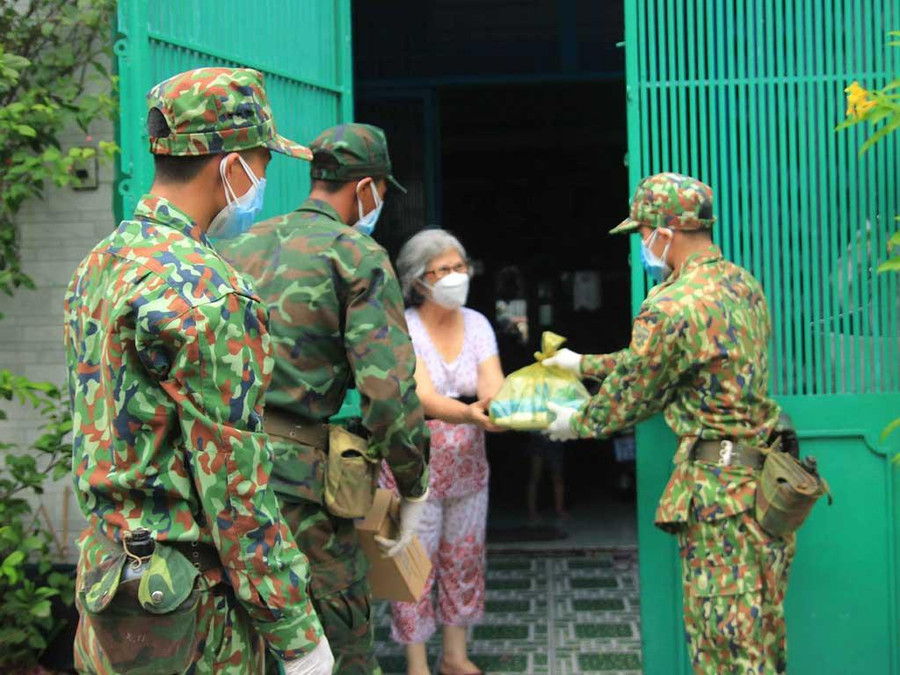 Cán bộ, chiến sĩ Sư đoàn 302 (Quân khu 7) phát lương thực, thực phẩm cho người dân trên địa bàn Q.7 trong cao điểm dịch Covid-19. Ảnh: Trác Rin