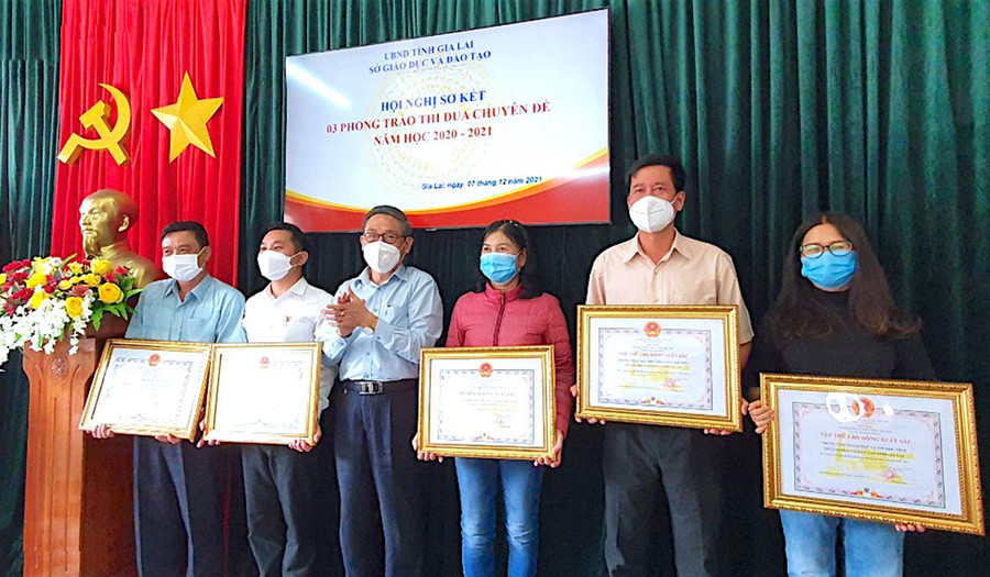 Thừa ủy quyền của Chủ tịch UBND tỉnh, Giám đốc Sở GD-ĐT Lê Duy Định trao tặng danh hiệu Tập thể lao động xuất sắc cho các tập thể. Ảnh: Mộc Trà.